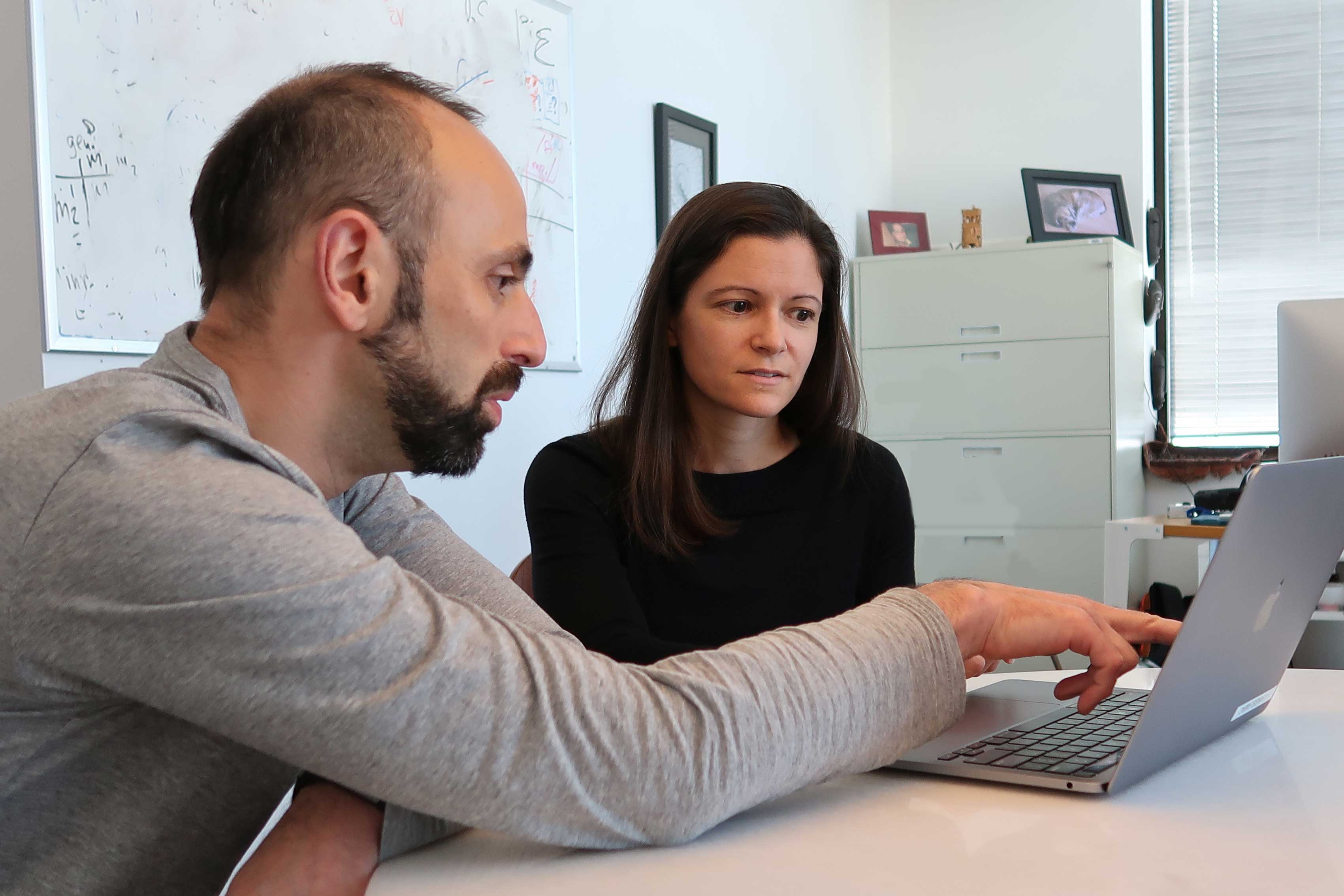 Faculty mentor and his mentee looking at data