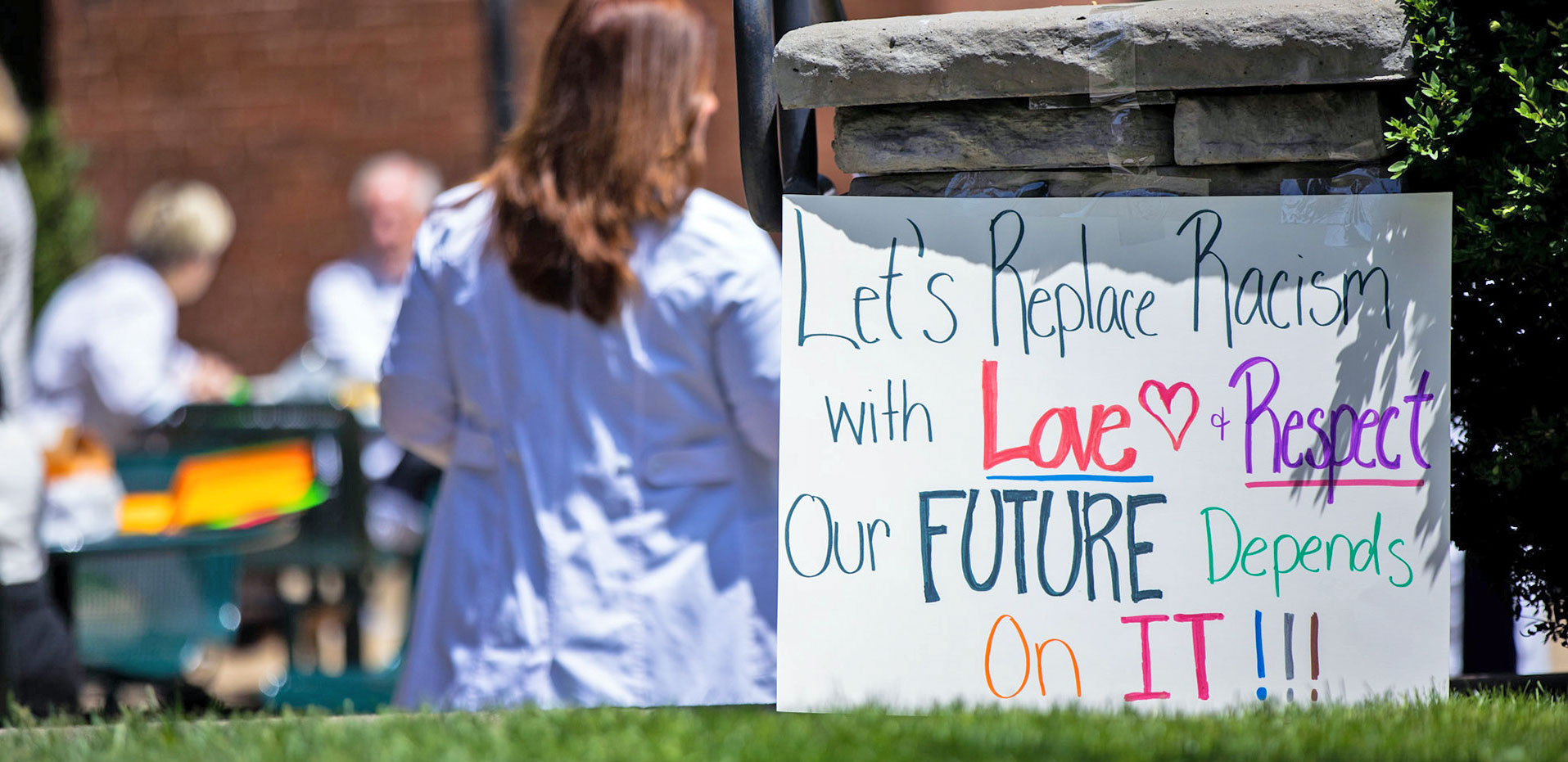 Sign with the message" Let's replace racism with love & respect"